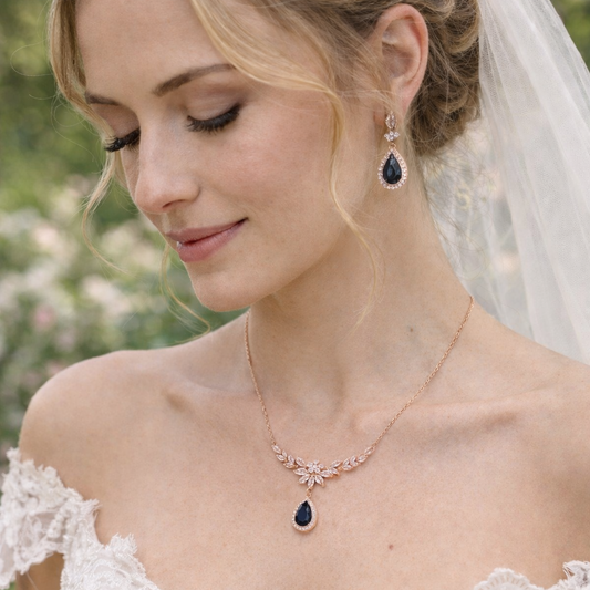 Bride wearing a necklace with a sapphire blue pendant in a garden setting
