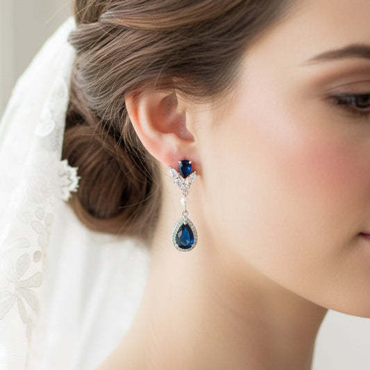 Close-up of a woman wearing a decorative earring with blue gemstones.