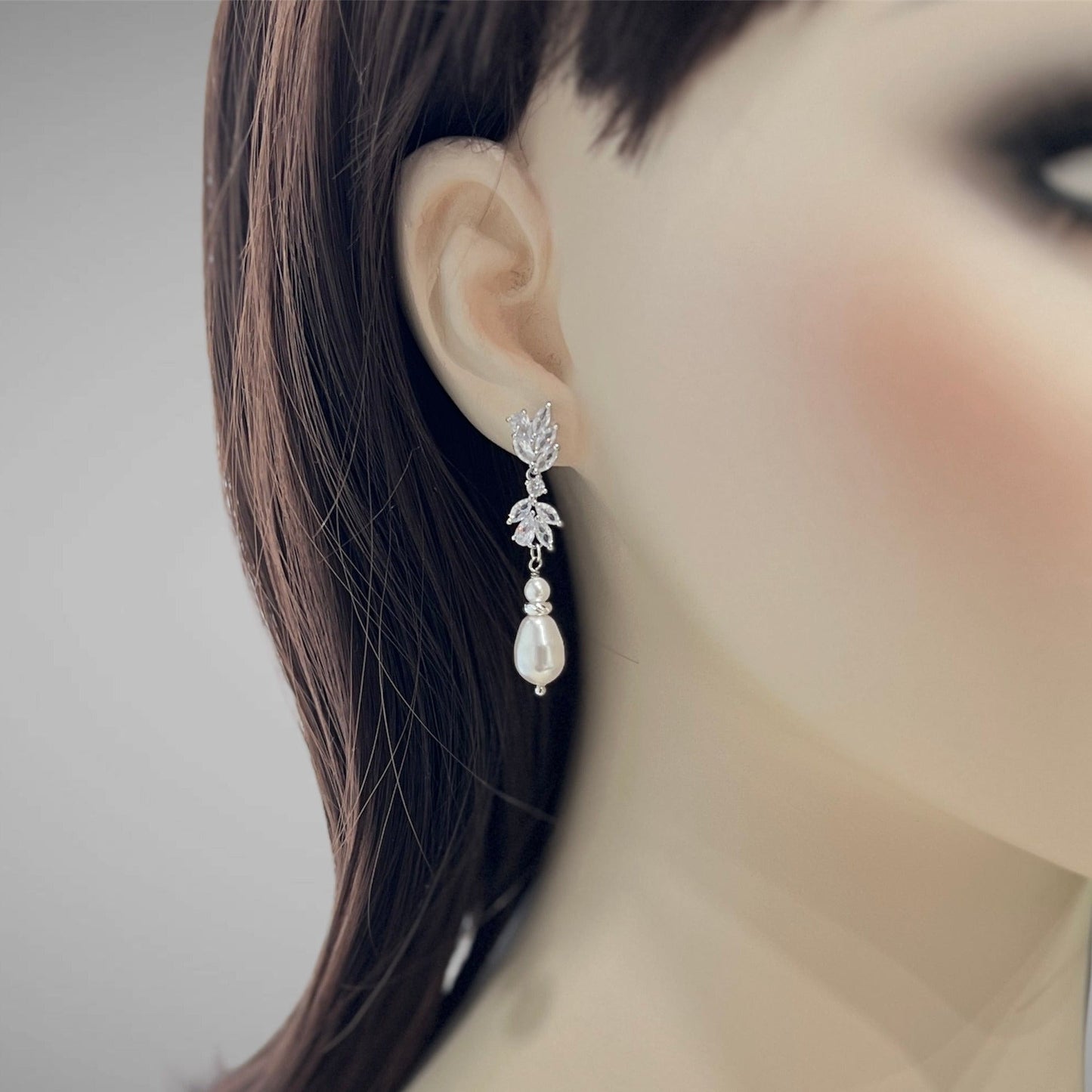 Earring worn on a mannequin ear with a blurred background