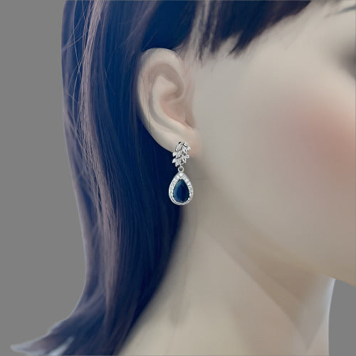 Sapphire blue teardrop gemstone earrings worn on a mannequin.