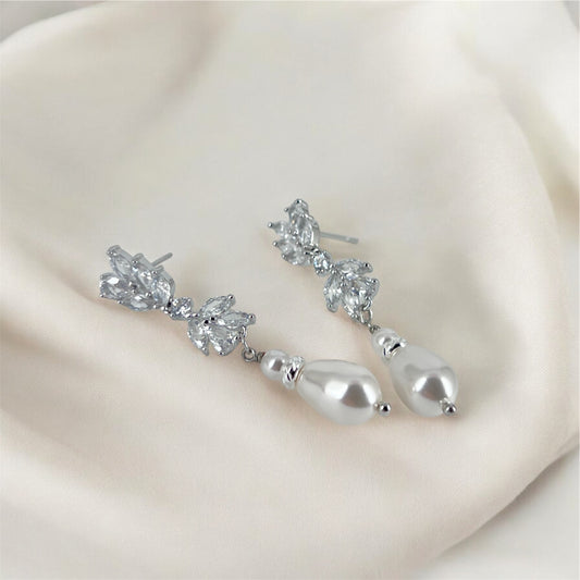 Silver CZ floral marquise earrings with pearl on a soft beige fabric background