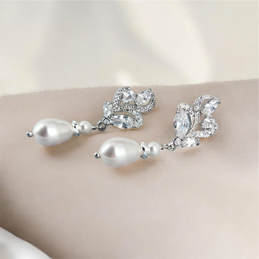 Pearl and marquise earrings on a neutral background