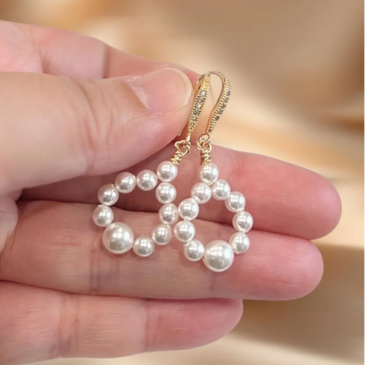 Bridal pearl hoop earrings worn on hand