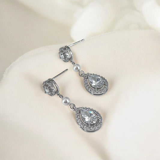 Silver teardrop earrings with clear stones on a white background