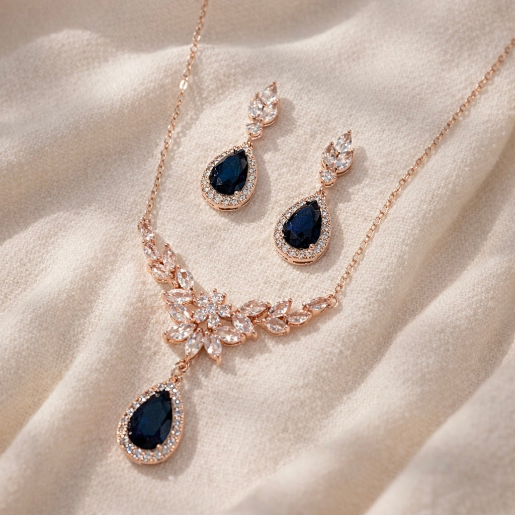 Jewelry set with necklace and earrings featuring blue stones on a beige fabric background