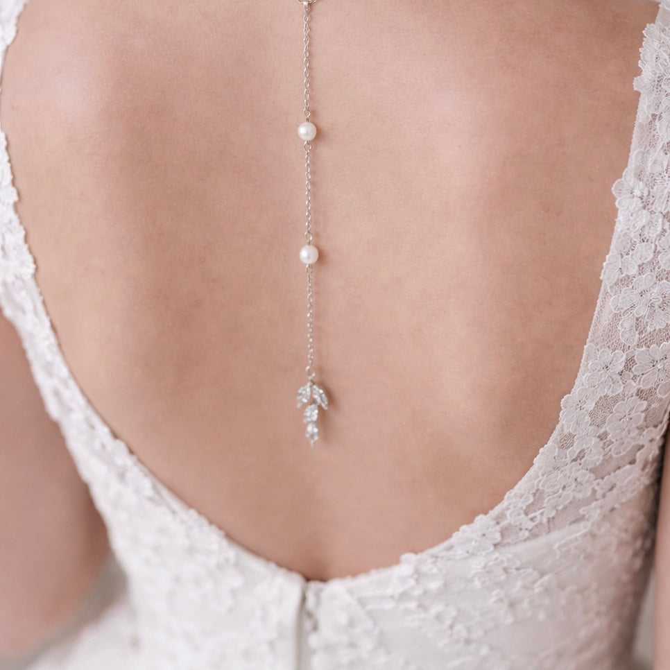 Pearl backdrop necklace on a model wearing a white lace garment
