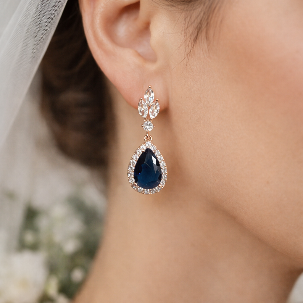 Close-up of a bride wearing a sapphire blue teardrop earring 
