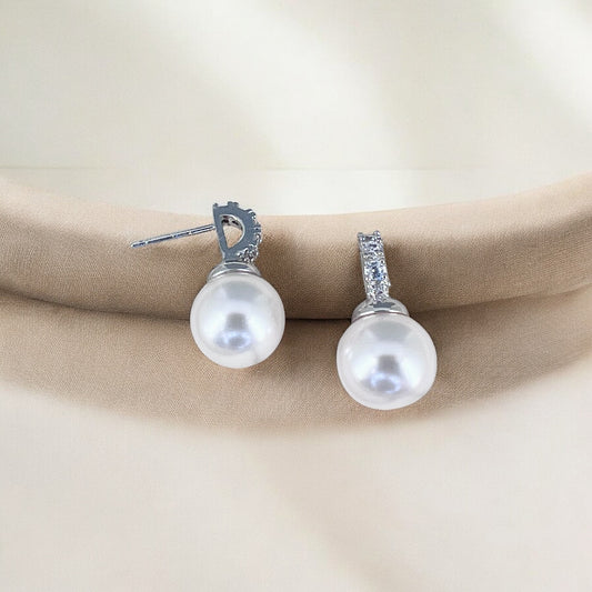 Handmade pearl wedding earrings showing luminous round pearls and silver crystal-set posts