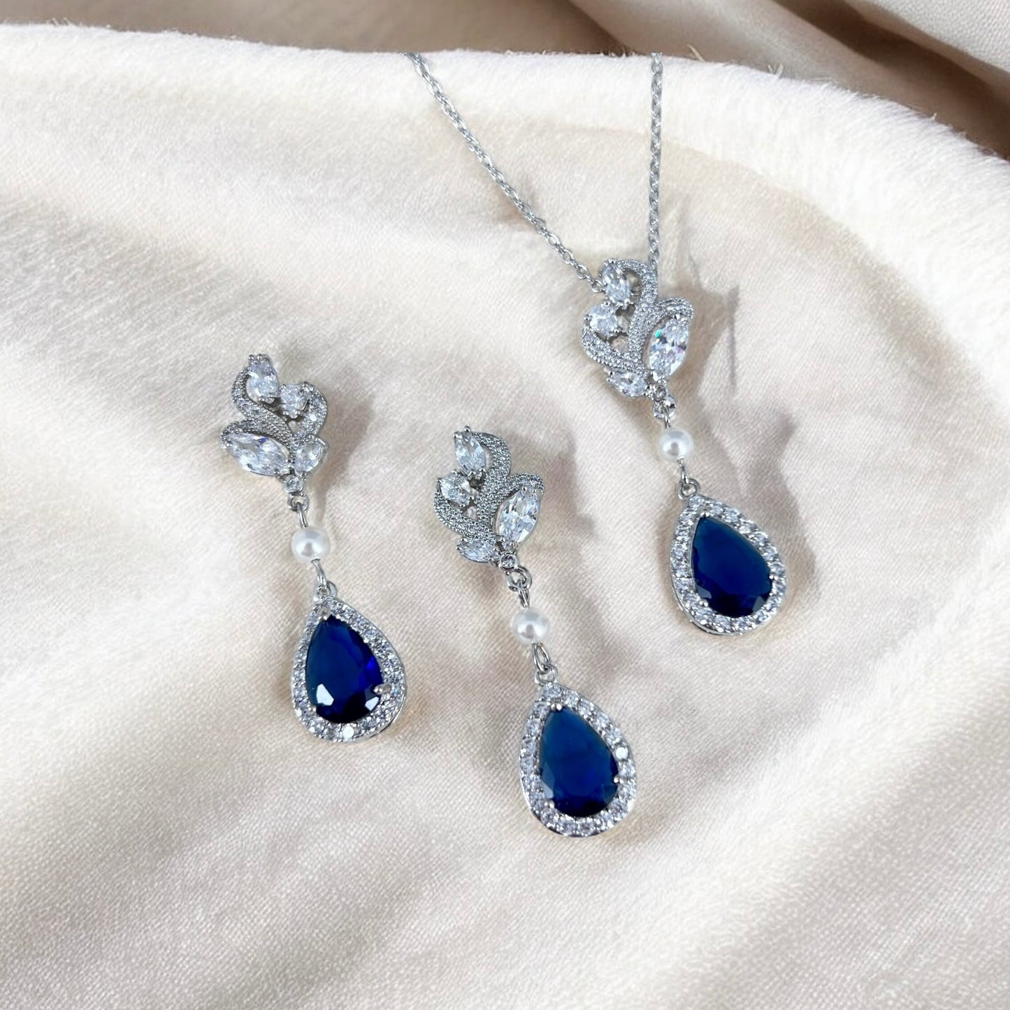 Teardrop sapphire crystal earrings and matching necklace with pearl accent photographed for bridal inspiration