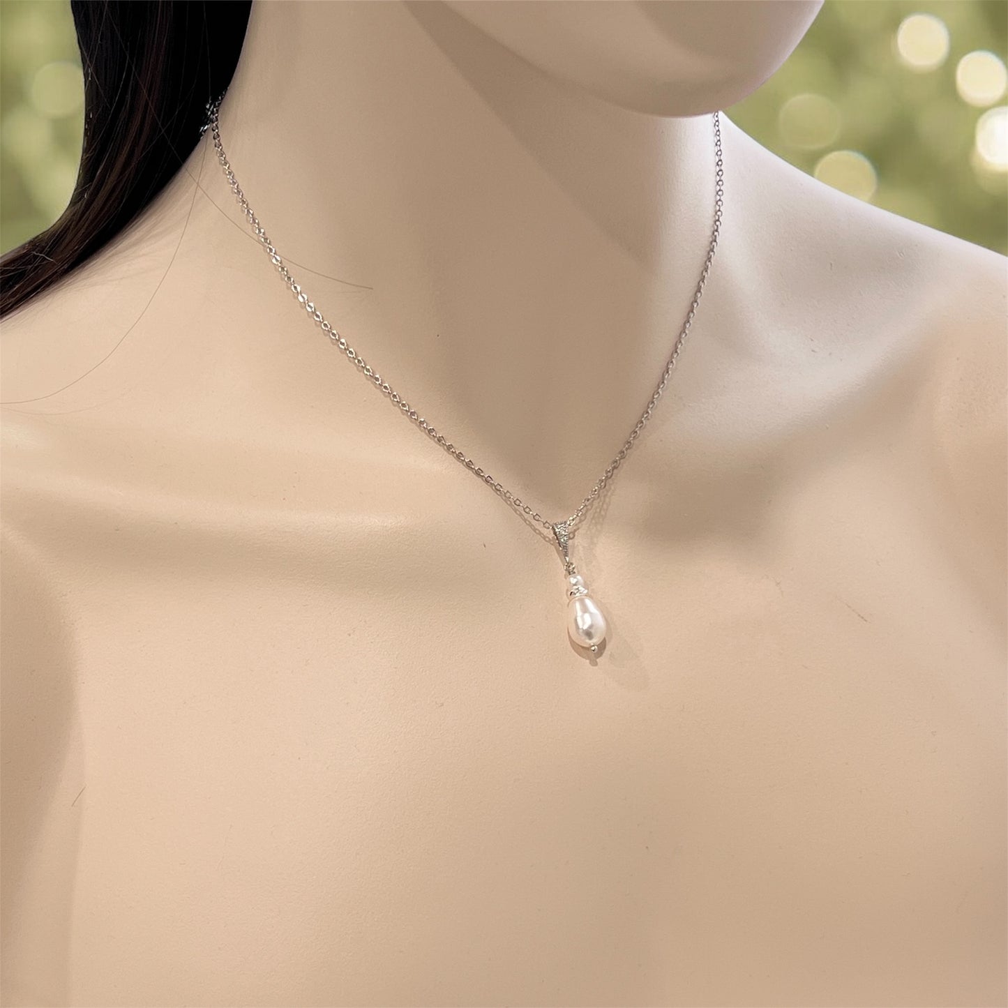 Pearl necklace on a mannequin with a blurred natural background
