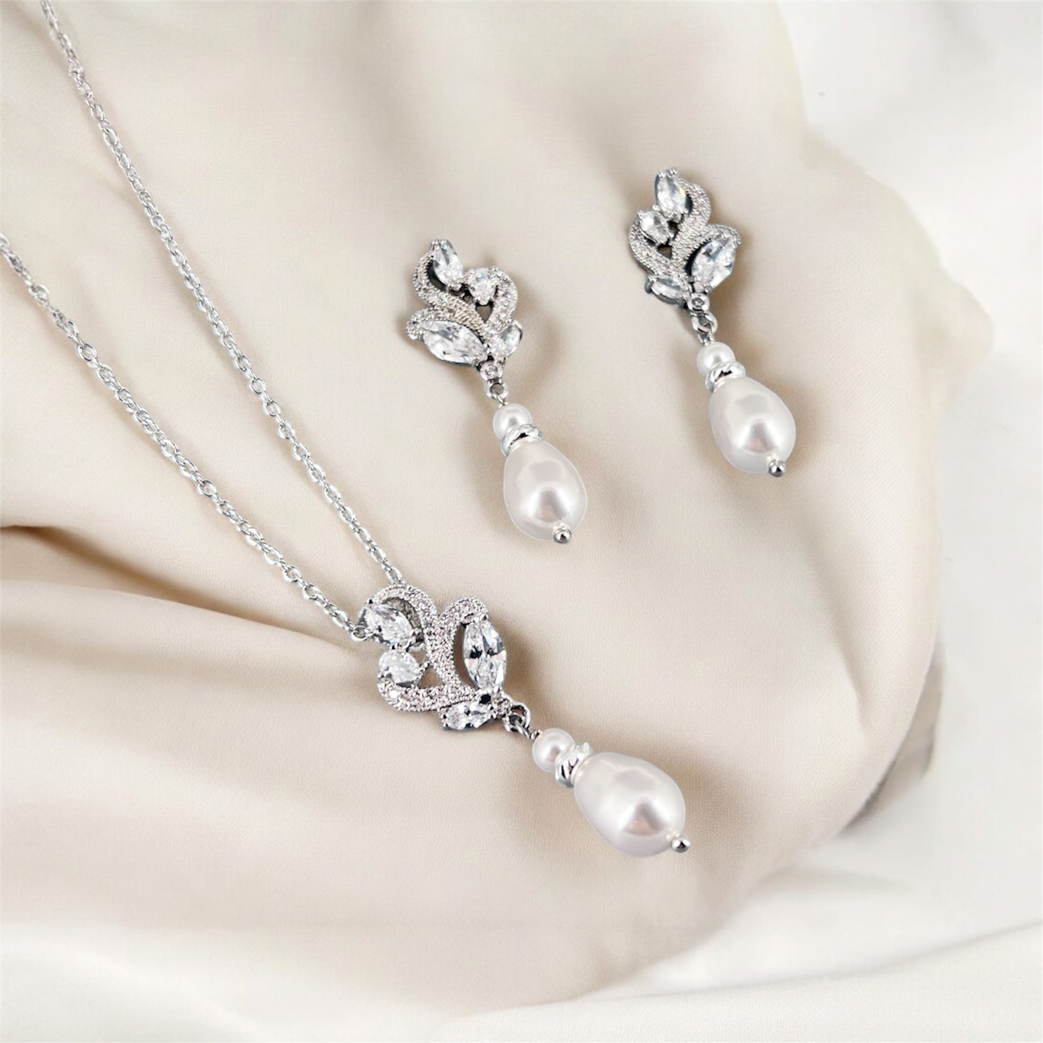 CZ floral pearl necklace and earrings on a beige fabric background