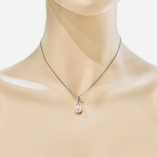 Pearl necklace on a mannequin with a plain background