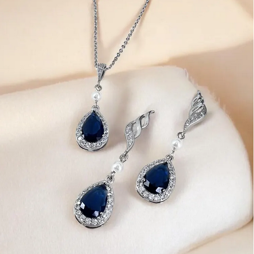 Navy blue teardrop earrings with silver detailing on a white surface