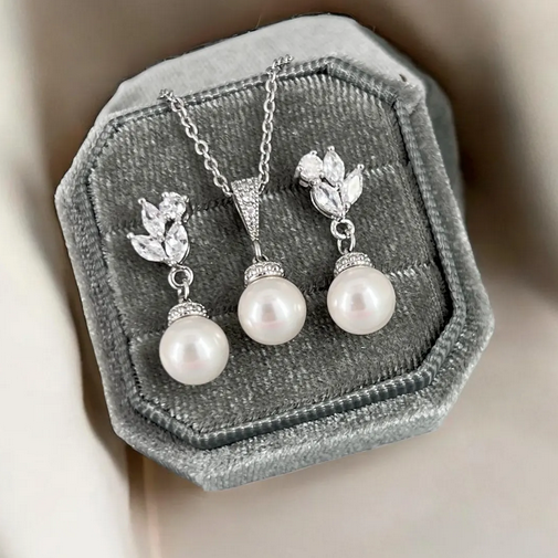 Pearl necklace and earrings set on a gray velvet stand