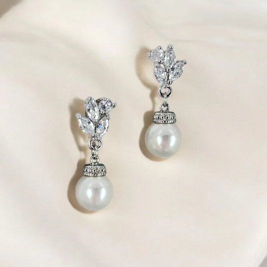 Pearl and crystal drop earrings on a light background
