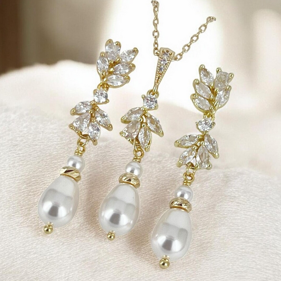 Gold setting CZ floral with pearl earrings and necklace jewelry set on a soft fabric background