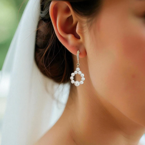Close-up of a bride with veil wearing pearl earrings outdoor