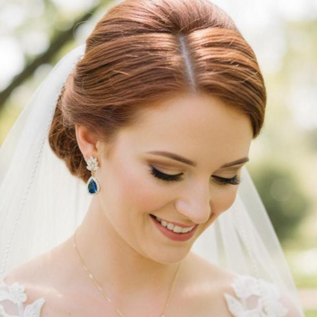 Bride with styled hair and veil wearing the gold tone sapphire blue clip on earrings