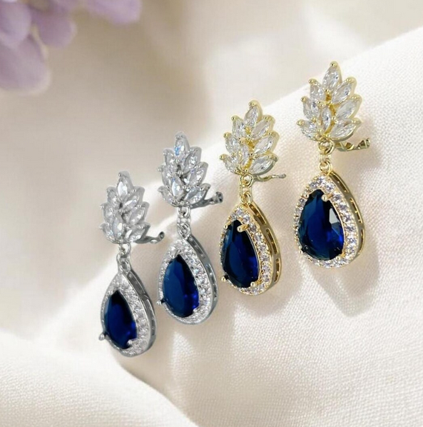 Navy blue wedding clip on teardrop with gold and silver settings on a soft background