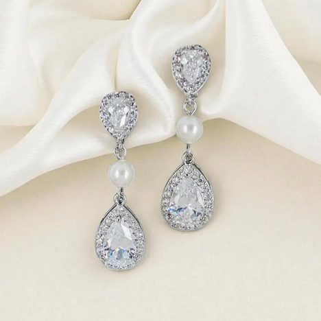Teardrop-shaped earrings with pearls and crystals on a white background