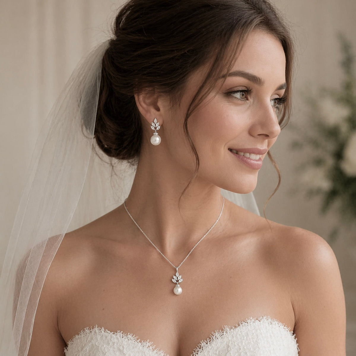 Bride wearing a necklace and earrings with a blurred background