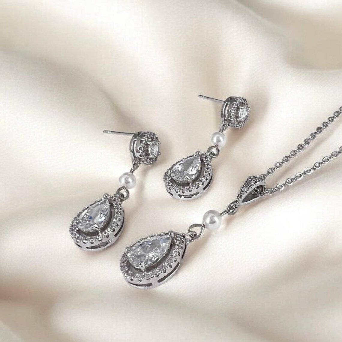 Bridal crystal drop earrings and necklace styled to show elongated silhouette and light reflection
