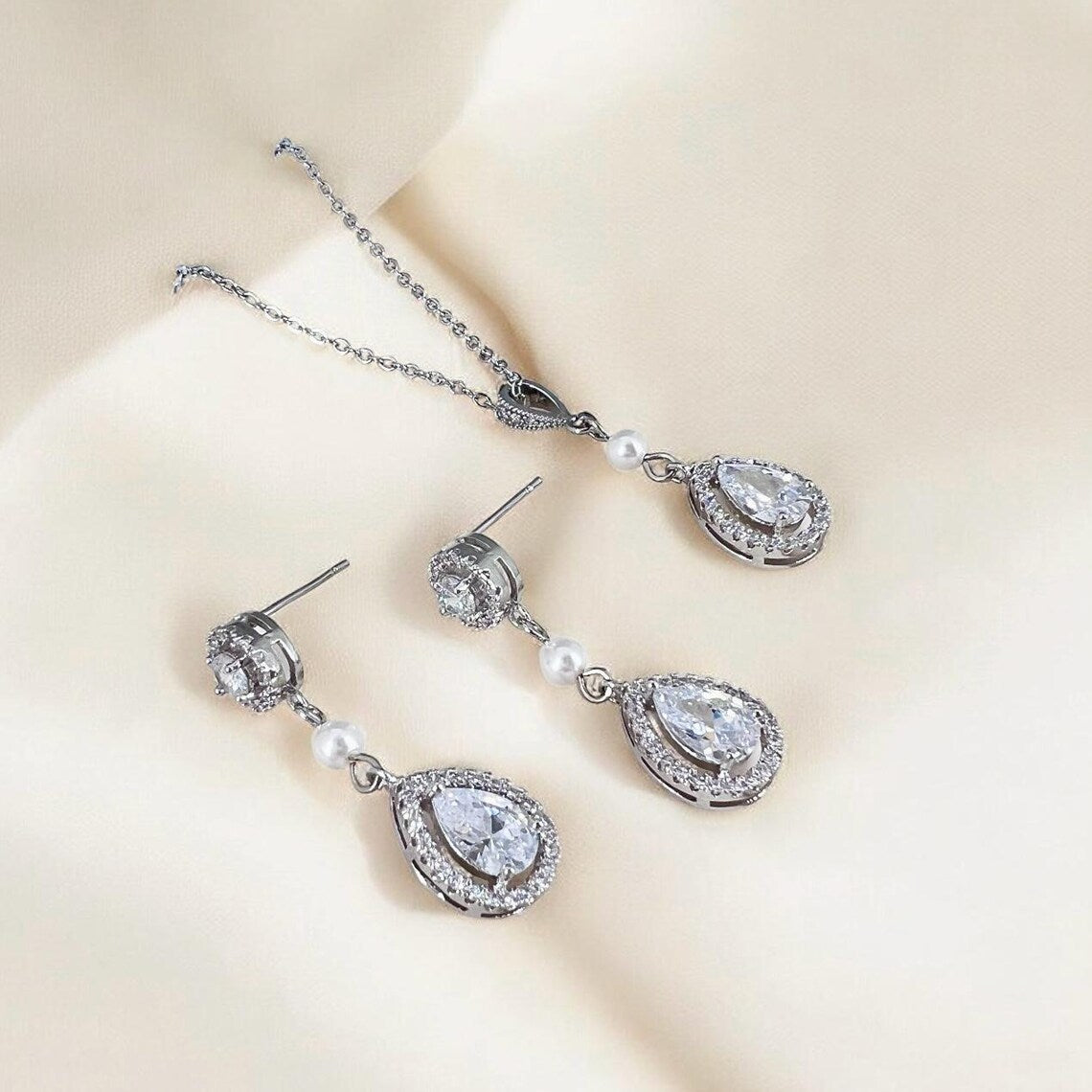 Handmade crystal wedding earrings and necklace showing round stud top and halo teardrop drop