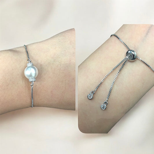 Close-up pearl adjustable bracelet highlighting luminous centerpiece on wrist against a beige background